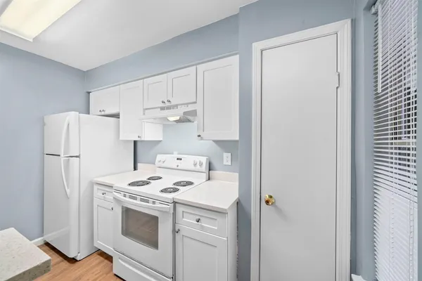 a kitchen with refrigerator a stove a sink and a window