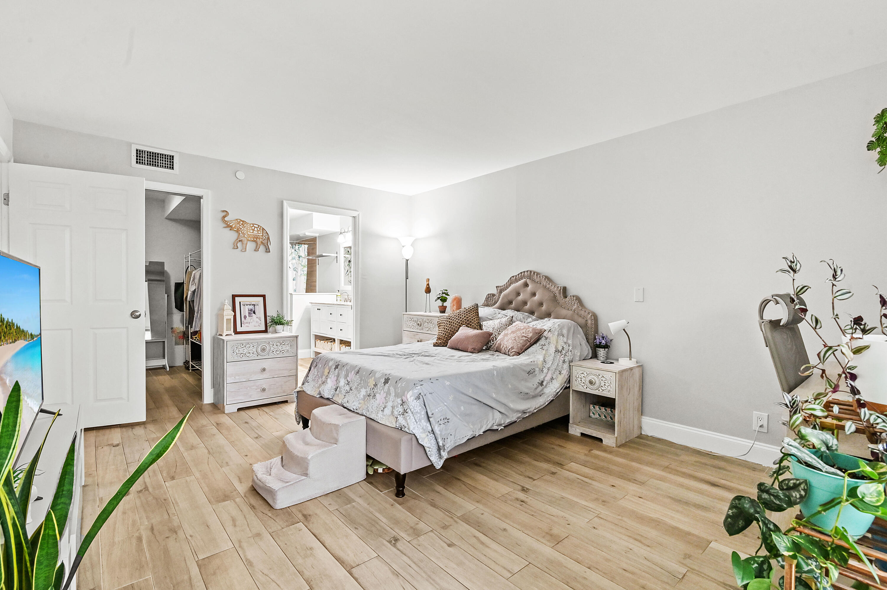 6400 Northwest 2nd Avenue, Unit 124 Boca Raton, FL 33487 - Photo 19 of 33 a bedroom with a bed and wooden floor