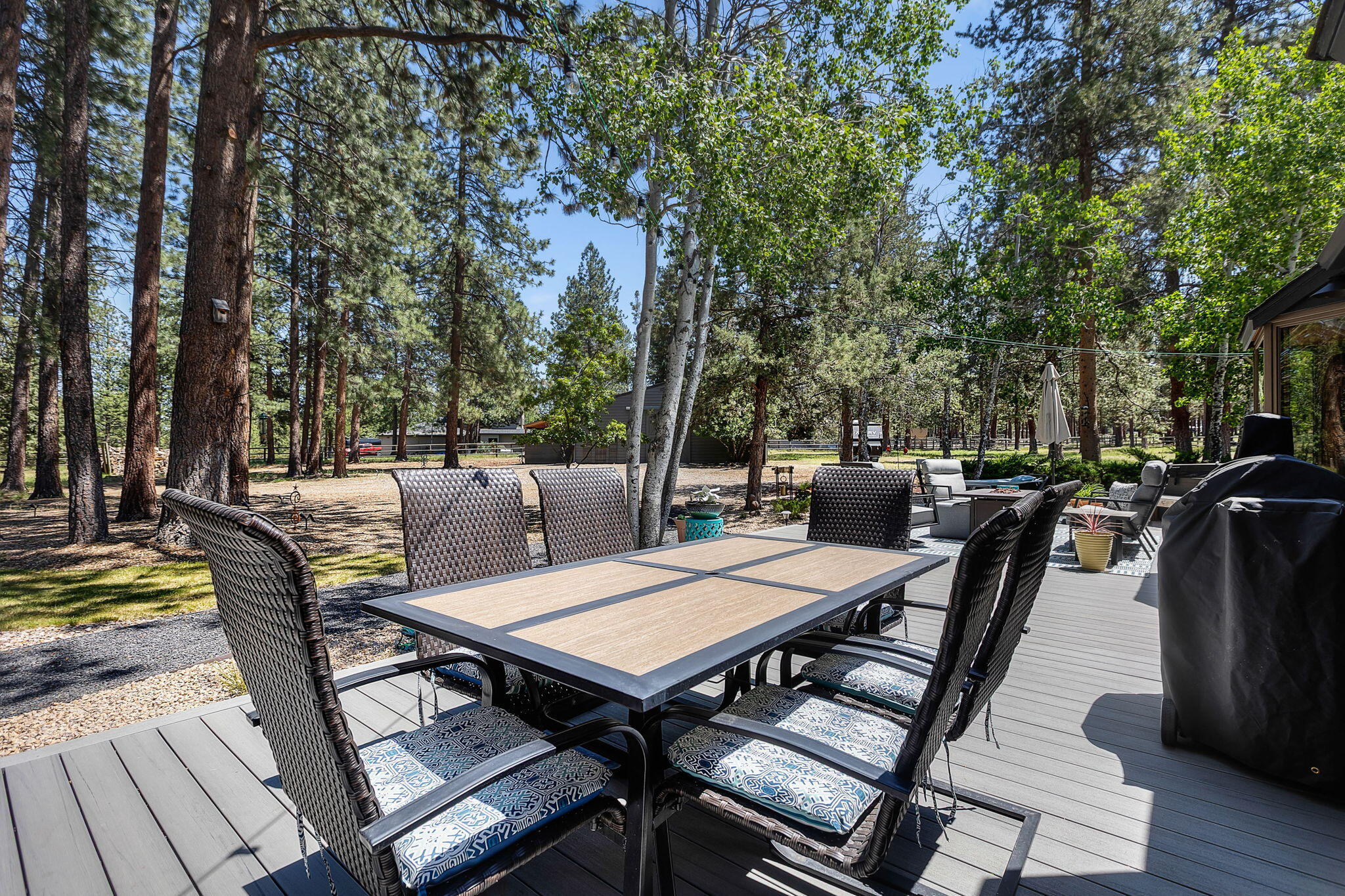 60210 East Ridgeview Drive Bend, OR 97702 - Photo 28 of 55 a view of a roof deck with table and chairs couches and a dining table with chairs and wooden floor