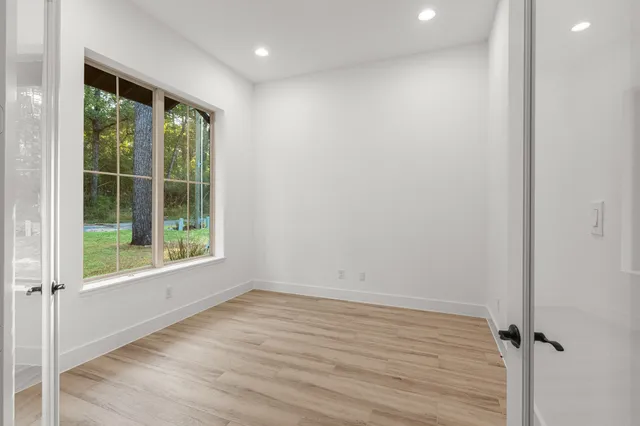 a view of a hallway with wooden floor and staircase