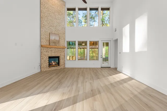 a large kitchen with stainless steel appliances granite countertop a large counter top a stove a refrigerator with white cabinets and wooden floor