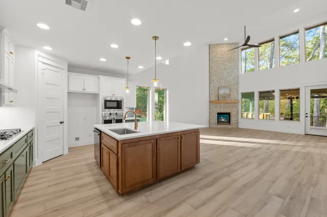 a kitchen with kitchen island a counter top space a sink stainless steel appliances and cabinets