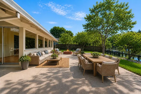 a view of a patio with table and chairs potted plants with wooden floor and fence