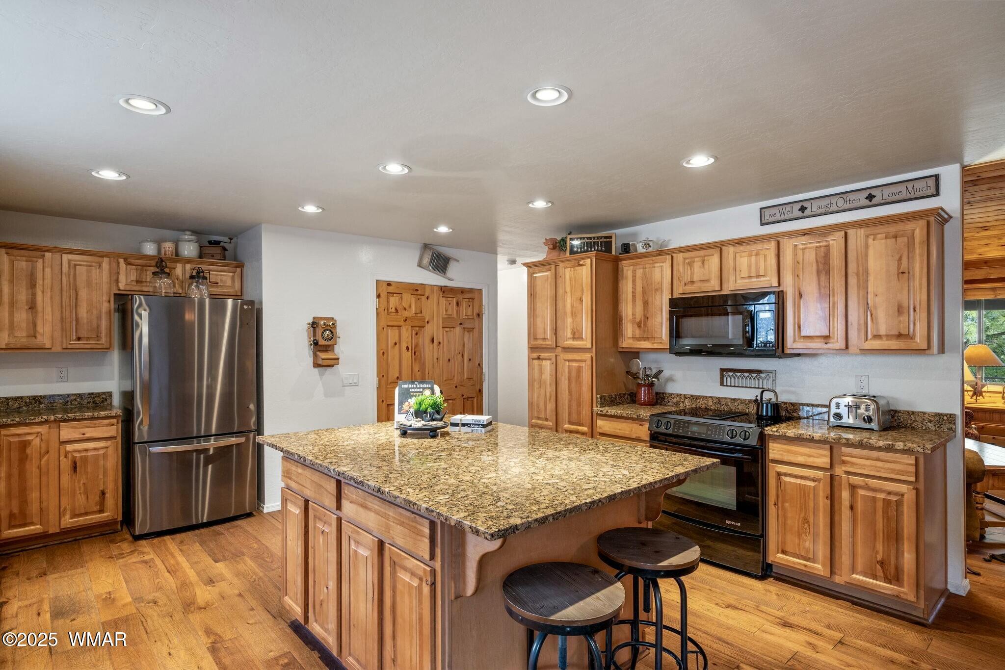 2938 Lodgepole Road Overgaard, AZ 85933 - Photo 13 of 43 a kitchen with stainless steel appliances granite countertop a refrigerator a stove a sink a dining table and chairs
