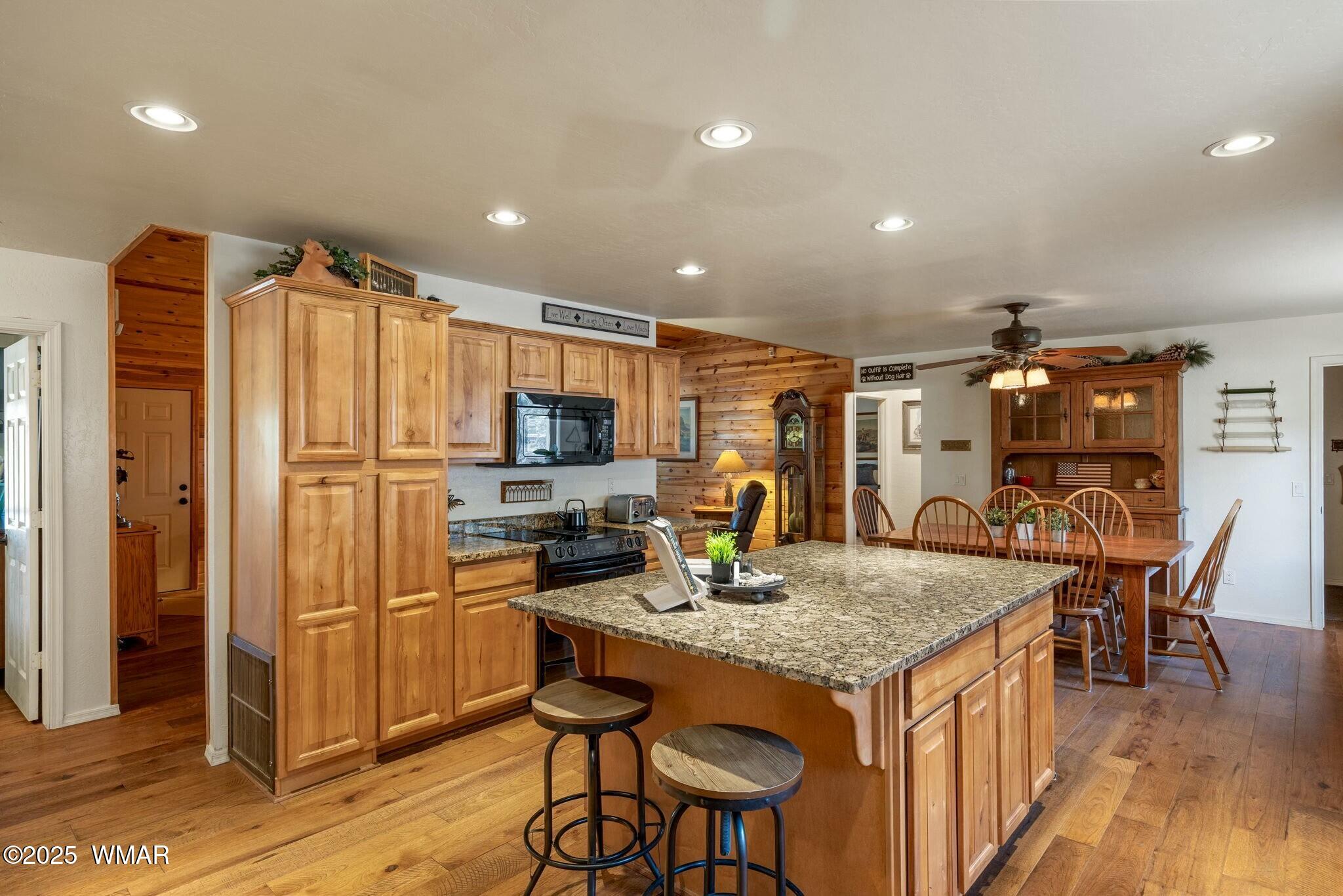 2938 Lodgepole Road Overgaard, AZ 85933 - Photo 14 of 43 a kitchen with granite countertop kitchen island stainless steel appliances a stove a sink a refrigerator cabinets and dining table