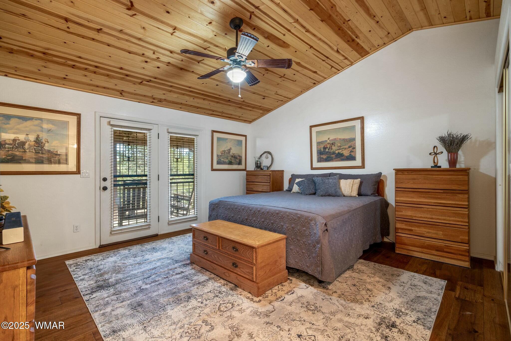 2938 Lodgepole Road Overgaard, AZ 85933 - Photo 16 of 43 a bedroom with a large bed a chandelier and dresser