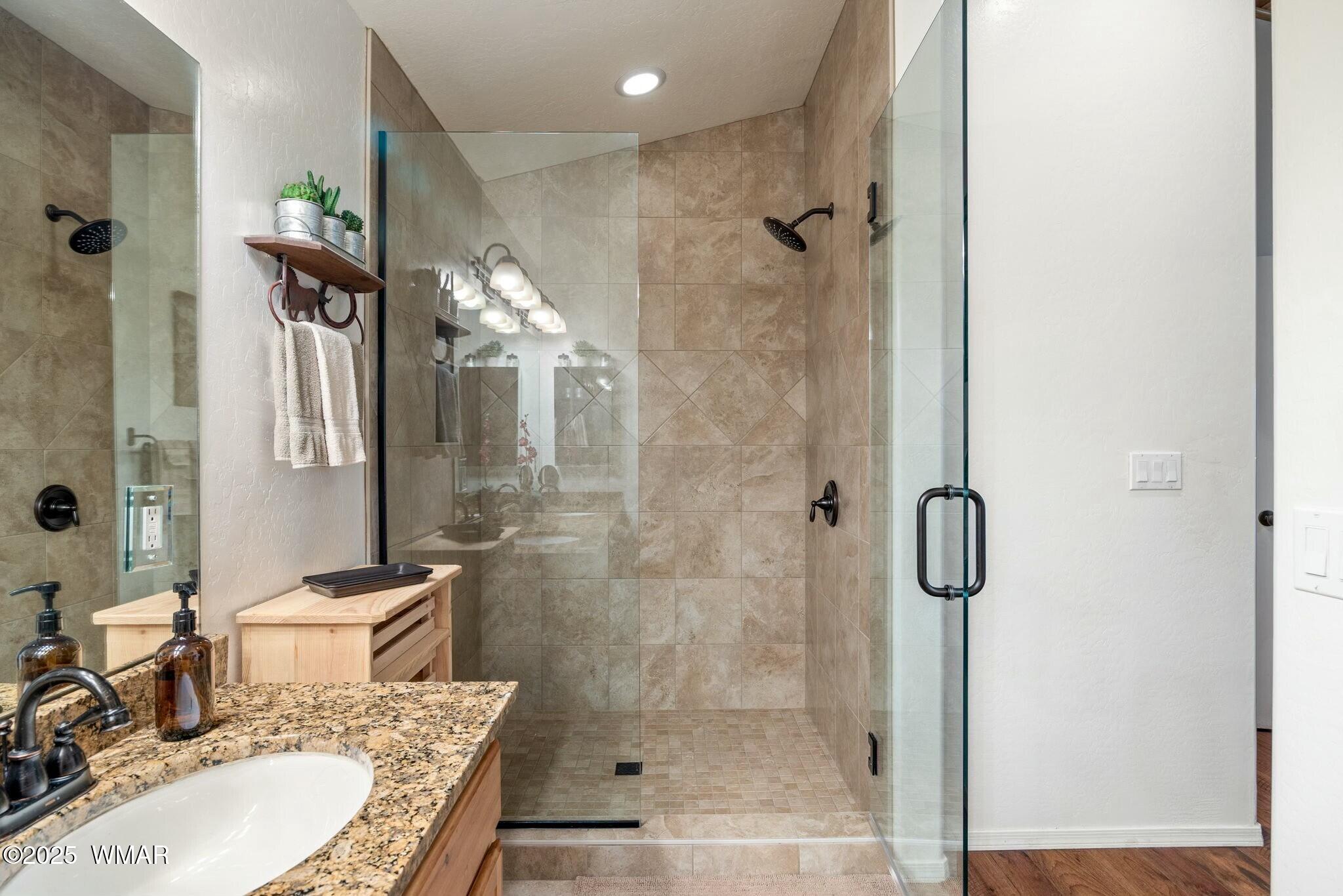 2938 Lodgepole Road Overgaard, AZ 85933 - Photo 19 of 43 a bathroom with a granite countertop shower sink vanity and mirror