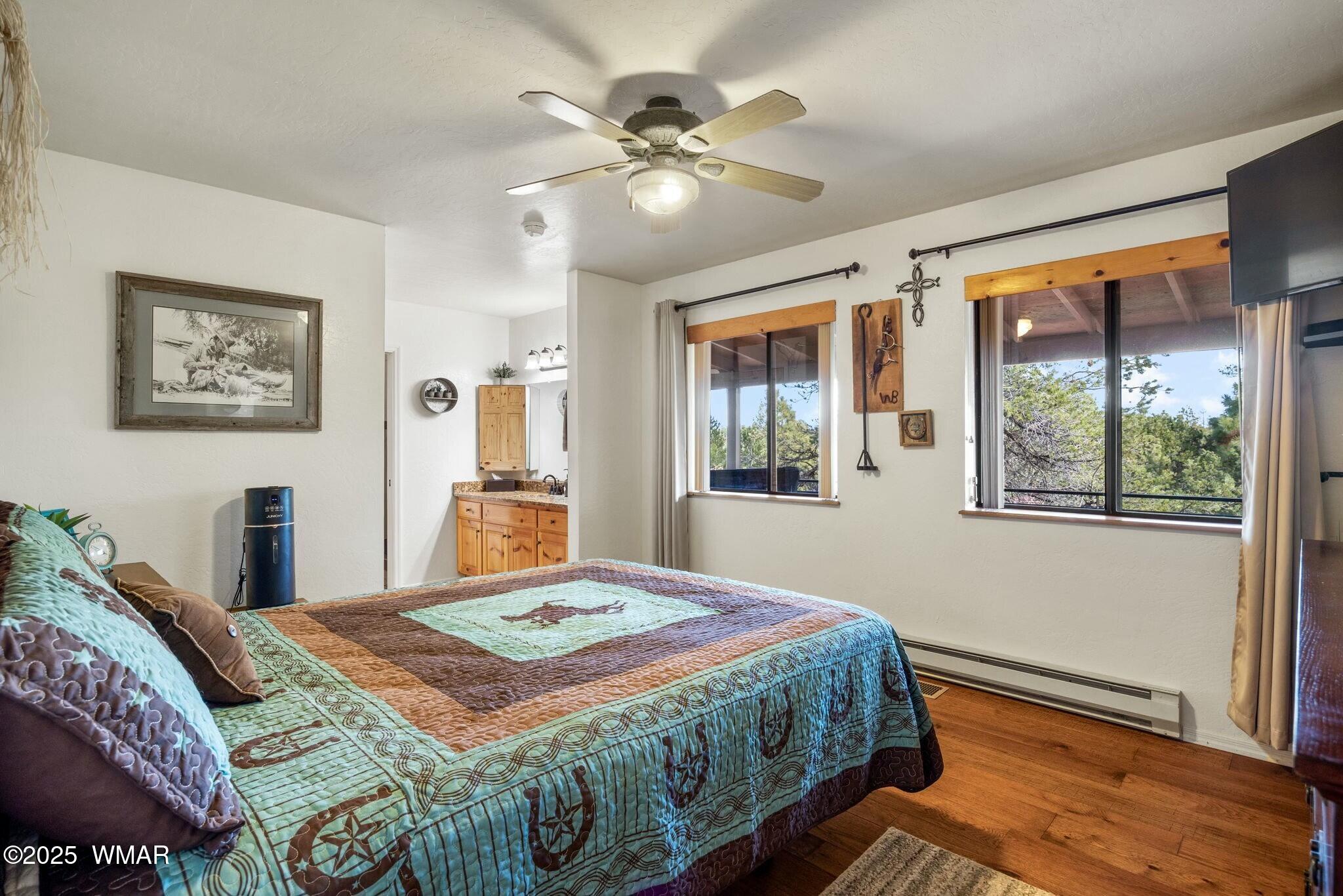 2938 Lodgepole Road Overgaard, AZ 85933 - Photo 20 of 43 a bedroom with a bed and a chandelier