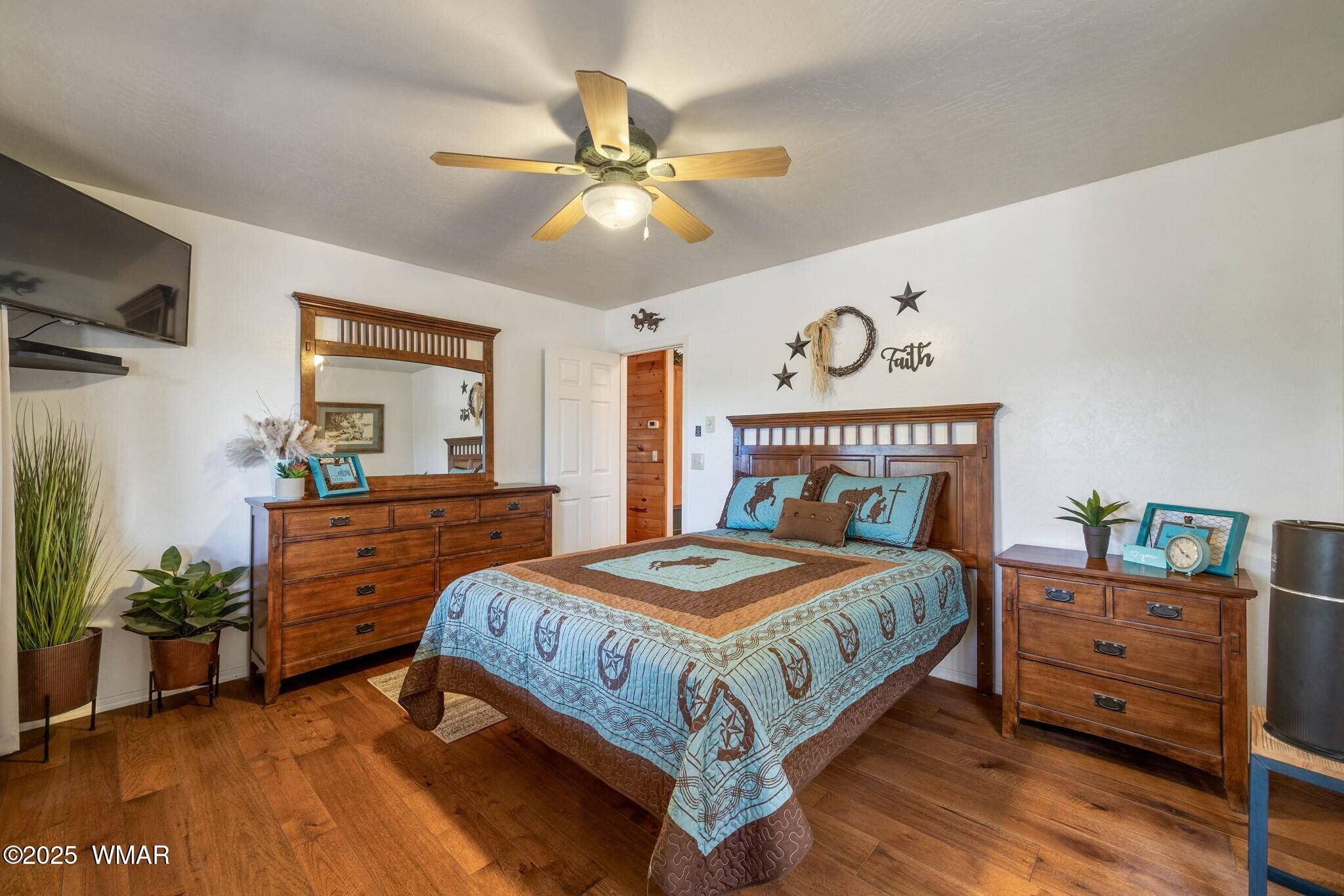 2938 Lodgepole Road Overgaard, AZ 85933 - Photo 21 of 43 a bedroom with a bed and a chandelier