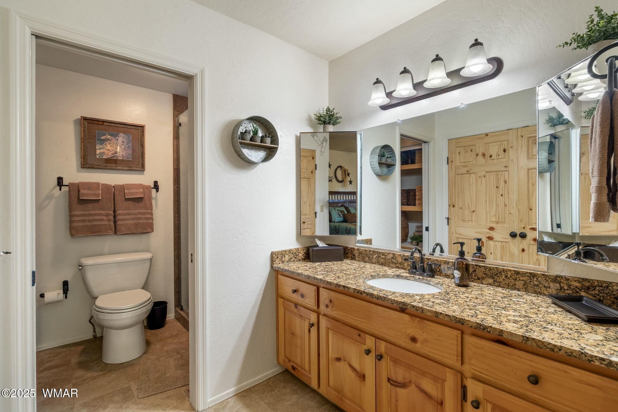 2938 Lodgepole Road Overgaard, AZ 85933 - Photo 22 of 43 a bathroom with a granite countertop sink and a mirror
