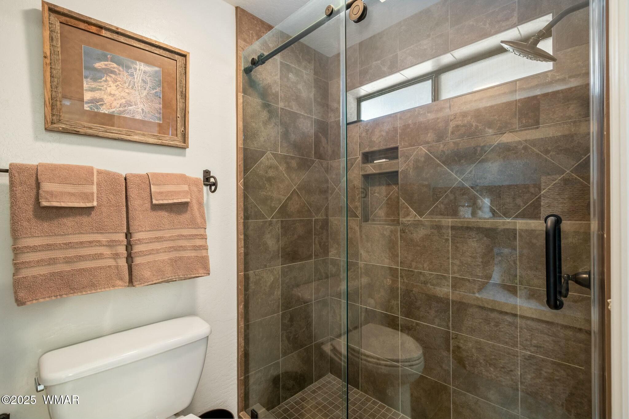 2938 Lodgepole Road Overgaard, AZ 85933 - Photo 23 of 43 a bathroom with a toilet and shower