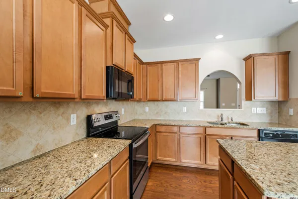 a kitchen with stainless steel appliances granite countertop a sink stove and cabinets
