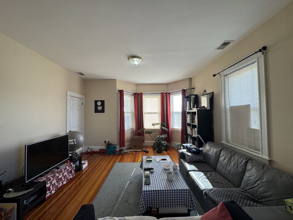 28 Quirk Street, Unit 28 Watertown, MA 02472 - Photo 2 of 23 a living room with furniture a flat screen tv and a fireplace