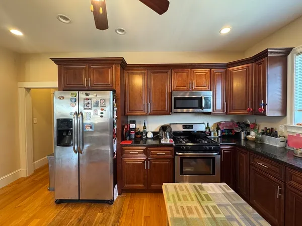 a kitchen with granite countertop a refrigerator stove and microwave