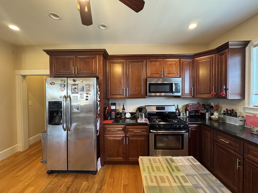 28 Quirk Street, Unit 28 Watertown, MA 02472 - Photo 7 of 23 a kitchen with granite countertop a refrigerator stove and microwave