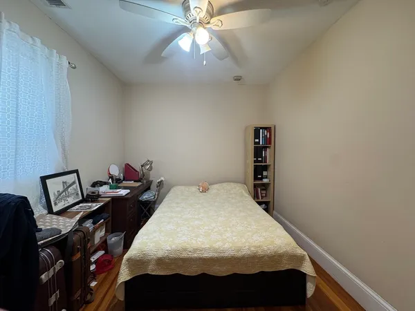 a bed sitting in a bedroom next to a window and a chandelier