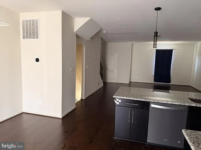 a large kitchen with stainless steel appliances granite countertop a stove and a wooden floors