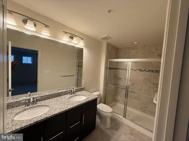 a view of kitchen with stainless steel appliances granite countertop a stove and a wooden floor