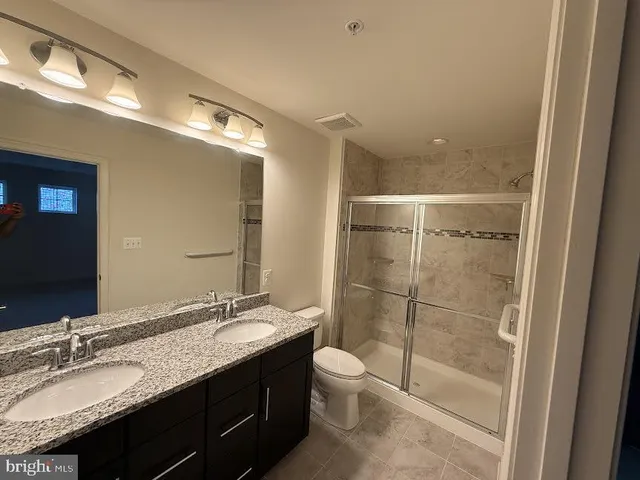 a bathroom with a granite countertop sink toilet and shower