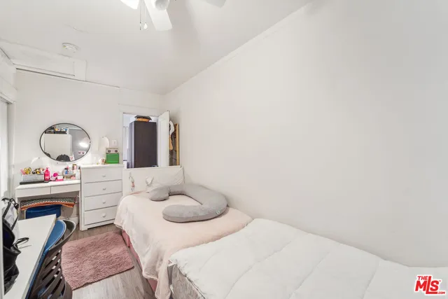 a bedroom with a bed and a large mirror on the dresser