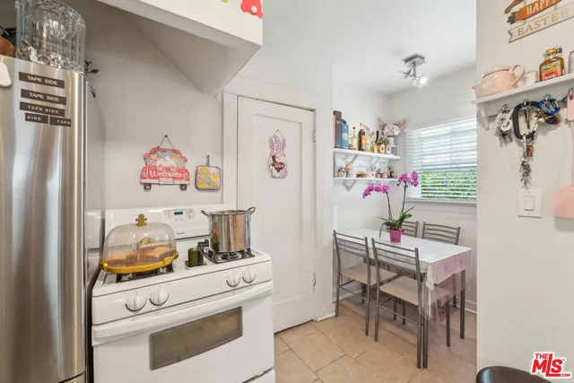 a white kitchen with a refrigerator and cabinets
