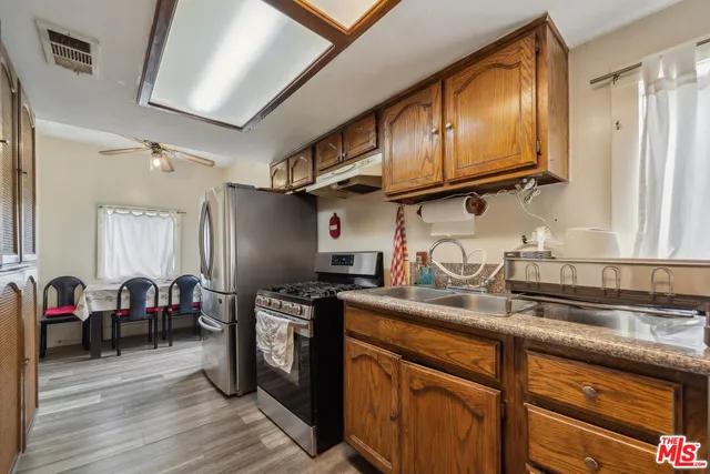 a kitchen with stainless steel appliances granite countertop sink stove top oven and cabinets