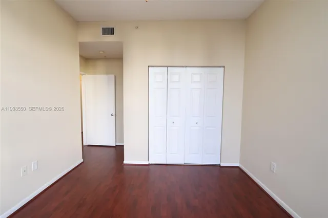 an empty room with wooden floor and closet