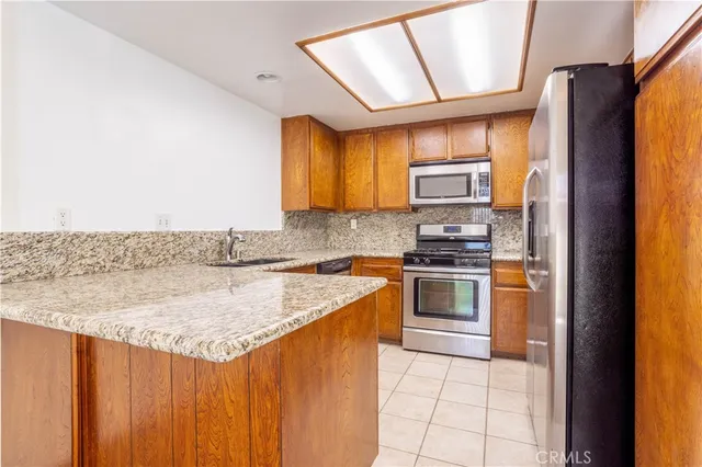 a kitchen with stainless steel appliances granite countertop a stove a sink and a refrigerator