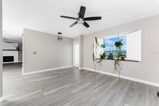 a view of a livingroom with wooden floor and a ceiling fan