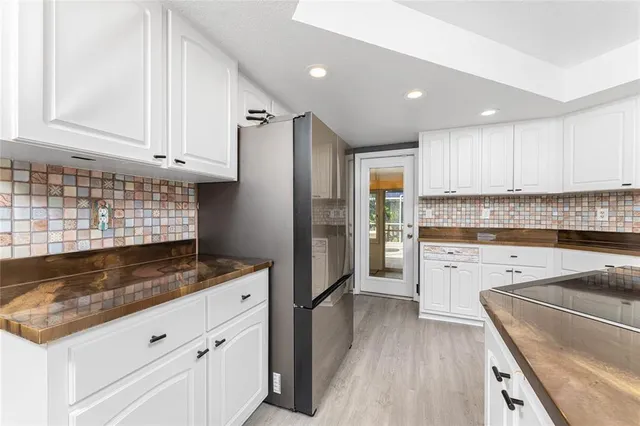 a kitchen with granite countertop white cabinets and white appliances
