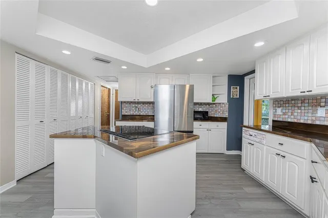 a large kitchen with stainless steel appliances granite countertop a stove a sink and a refrigerator