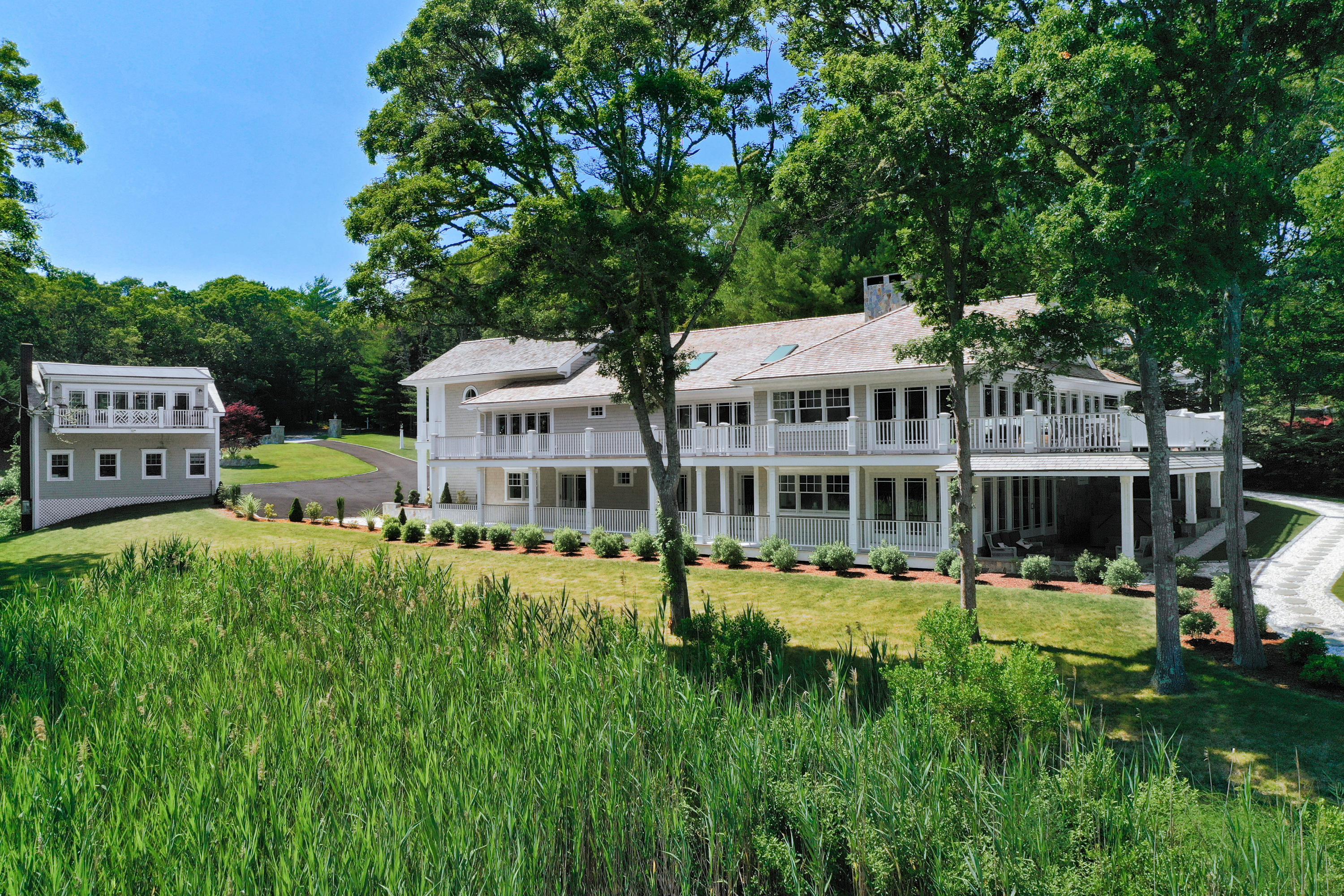 94 Starboard Lane Osterville, MA 02655 - Photo 5 of 47 a front view of a house with a garden and trees