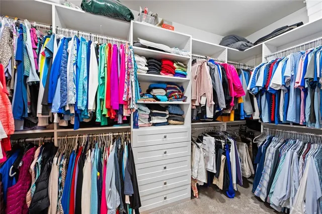 a view of walk in closet with clothes and shoes