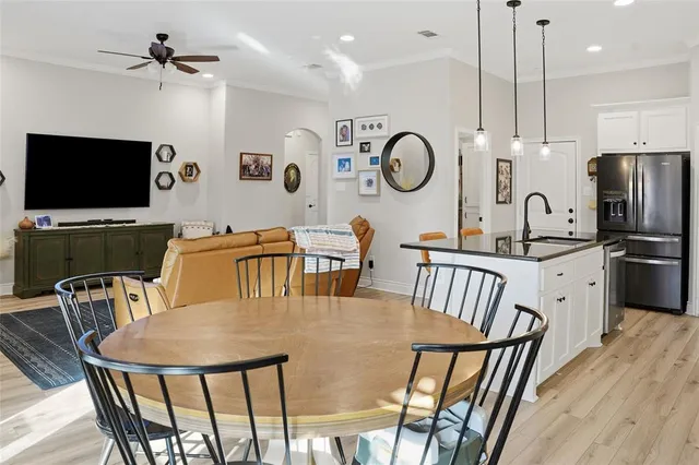 a kitchen with stainless steel appliances granite countertop a stove a kitchen island a dining table and chairs