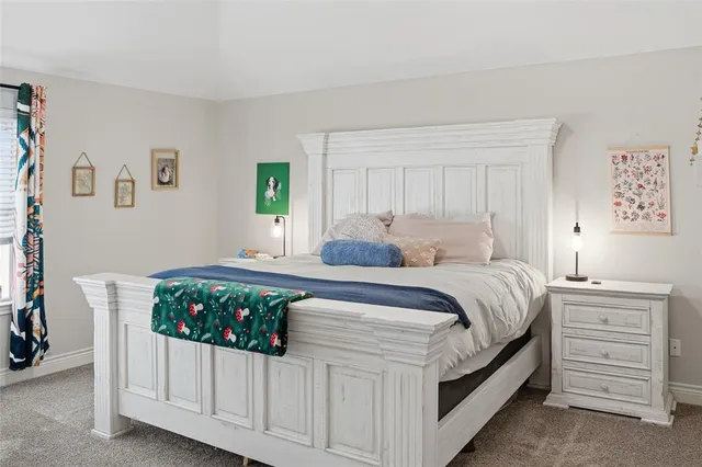 a bedroom with a bed a dresser and a window