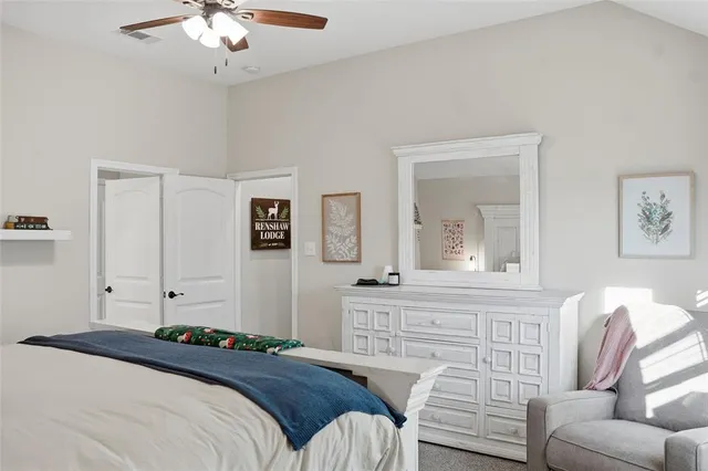a bedroom with a bed furniture and painting on the wall
