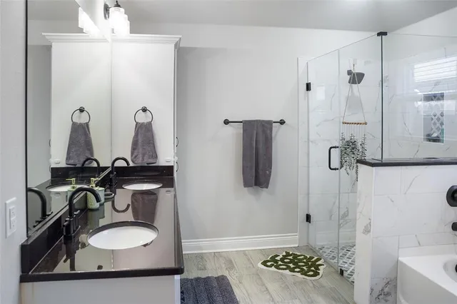 a bathroom with a bathtub a window and a shower