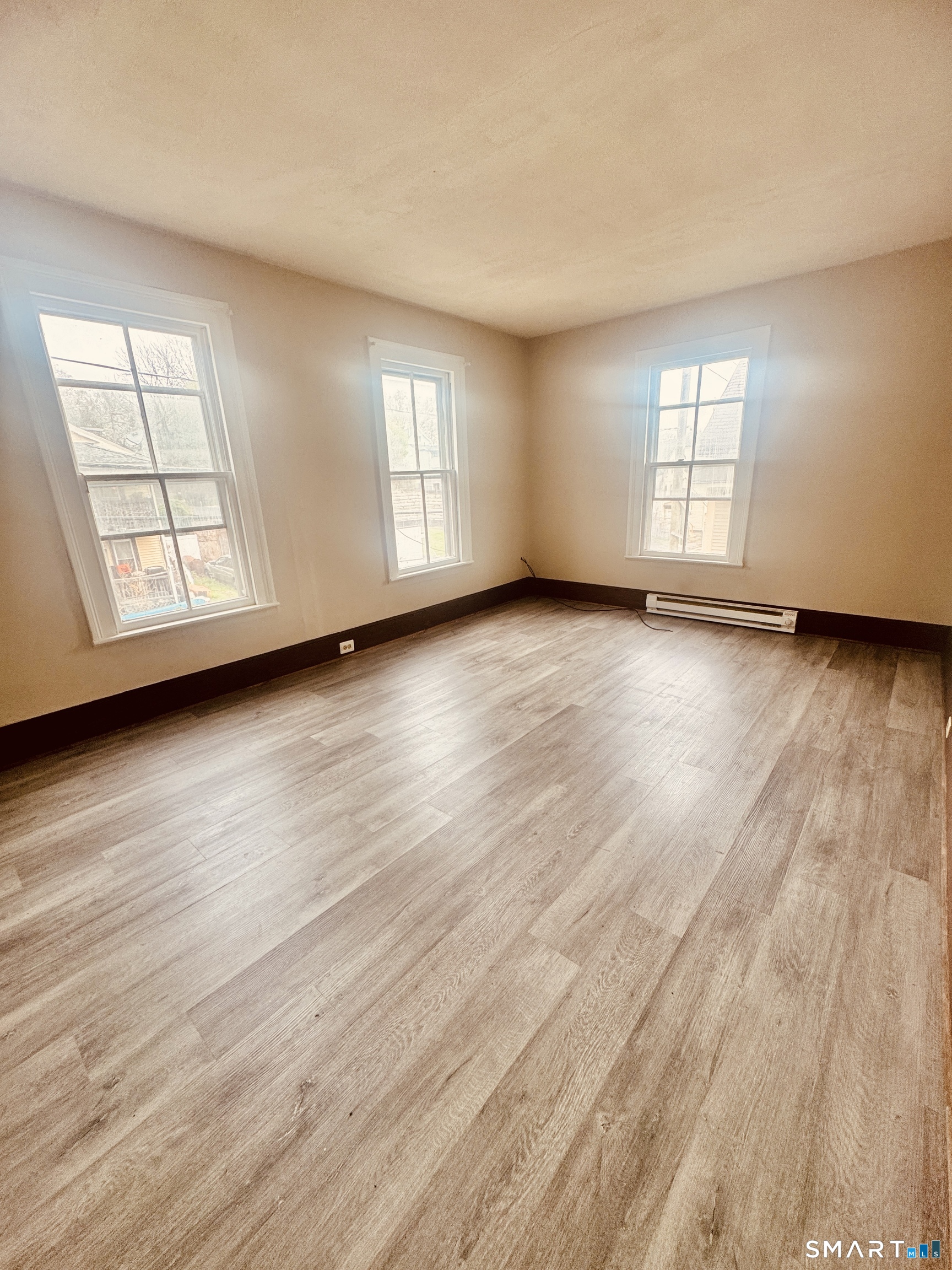 59 Green Street Waterbury, CT 06708 - Photo 3 of 6 an empty room with wooden floor and windows