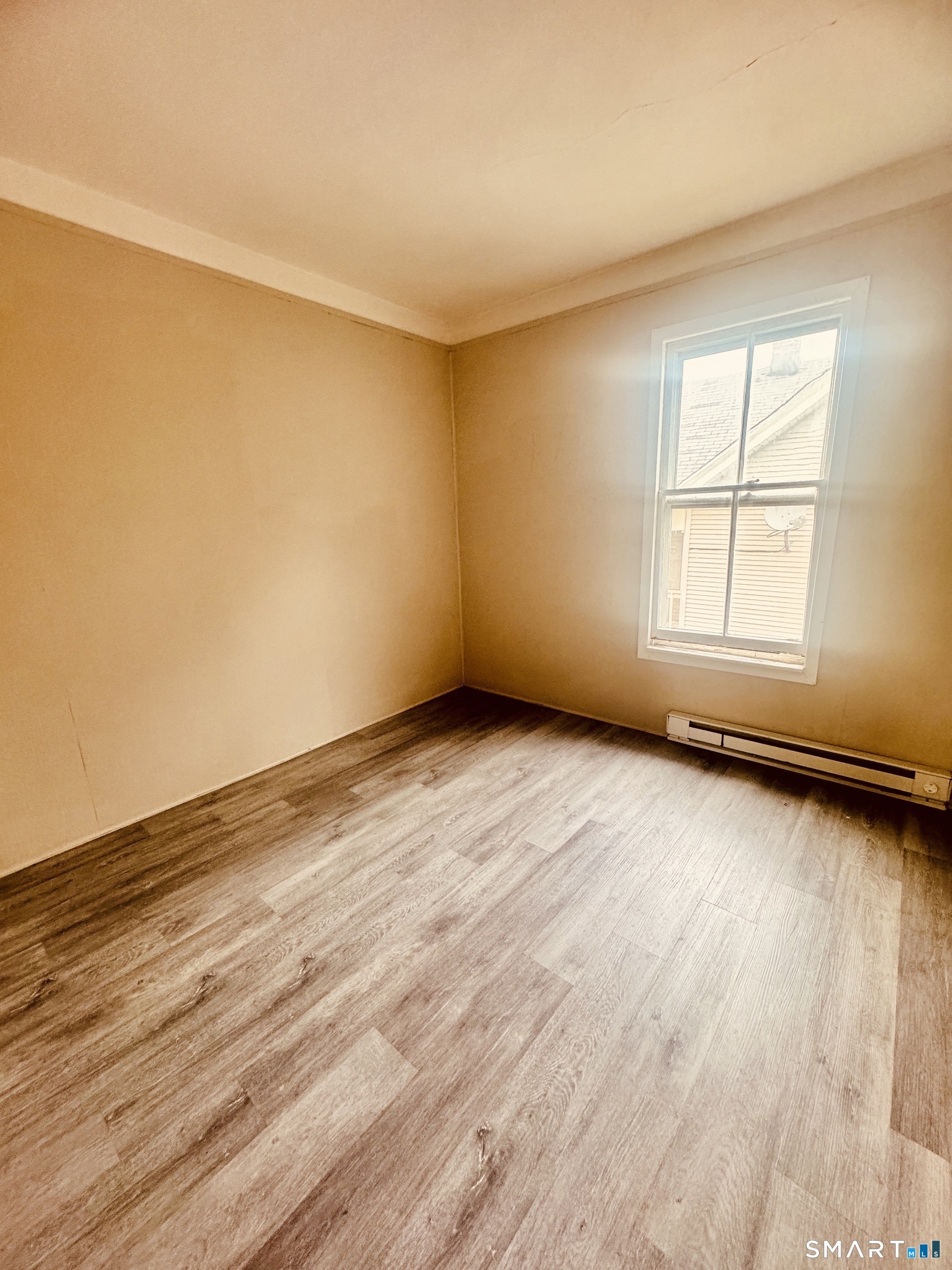 59 Green Street Waterbury, CT 06708 - Photo 4 of 6 an empty room with wooden floor and windows
