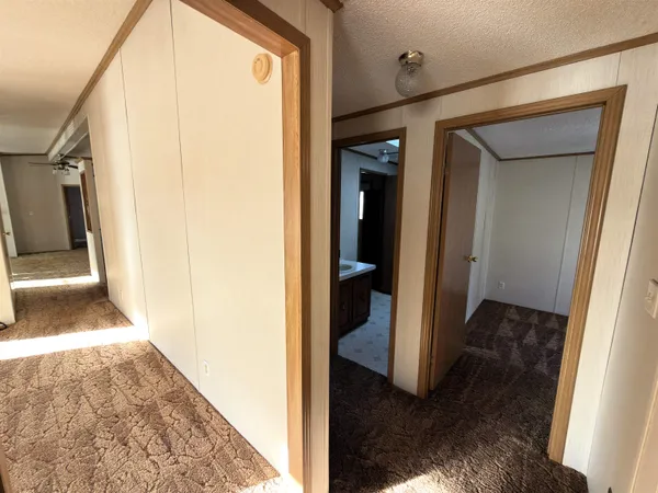 a view of a hallway with wooden floor and a living room
