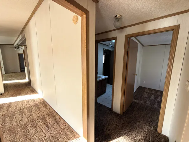 a view of a hallway with wooden floor and a living room