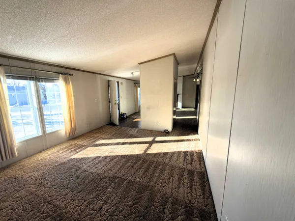 a view of a hallway view with wooden floor and a living room