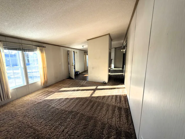a view of a hallway view with wooden floor and a living room