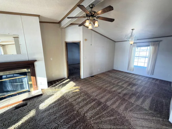 a view of an empty room with a fireplace and a window