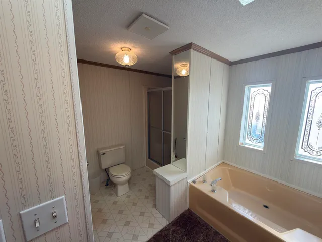 a bathroom with a tub a toilet and a sink