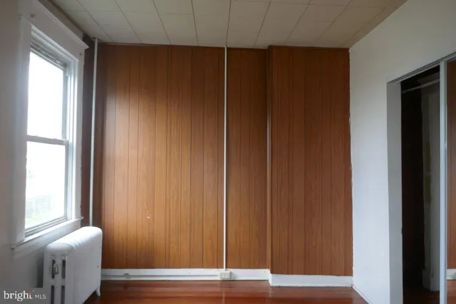 an empty room with wooden floor and a window