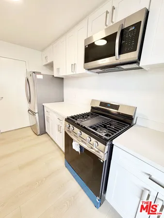 a stove top oven sitting inside of a kitchen