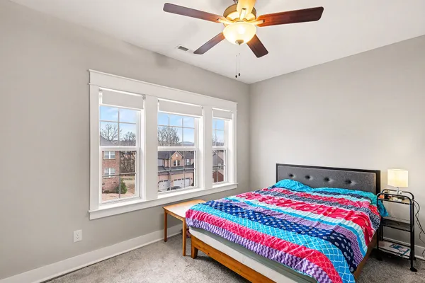 a bedroom with a bed a chandelier and a window