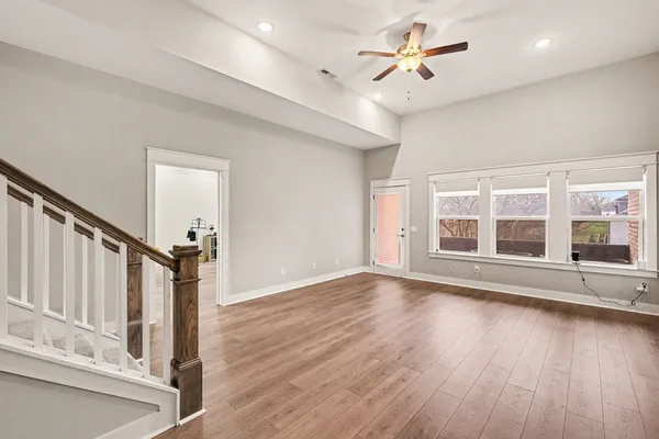 a view of an empty room with a window and wooden floor