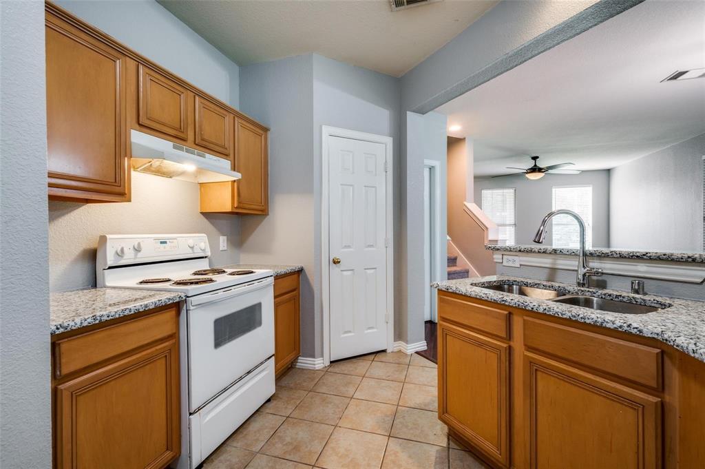 9801 Cedarcrest Drive Providence Village, TX 76227 - Photo 16 of 23 a kitchen with a sink stove and cabinets